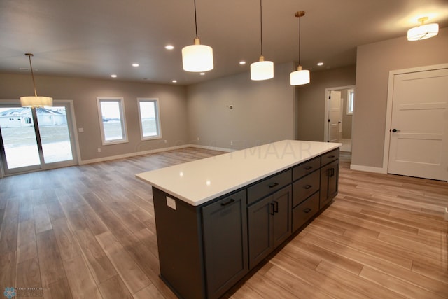 kitchen featuring decorative light fixtures, light wood-type flooring, and a kitchen island