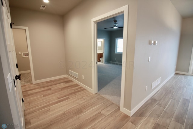 corridor featuring light colored carpet