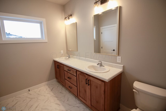 bathroom with tile flooring, vanity with extensive cabinet space, toilet, and double sink