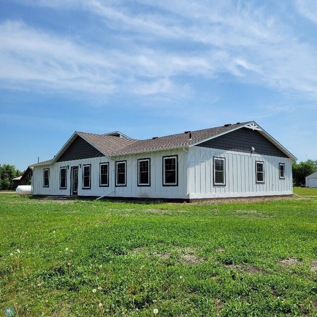 rear view of property featuring a lawn