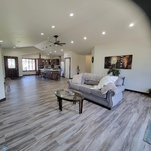 living room with lofted ceiling, ceiling fan, and light hardwood / wood-style floors