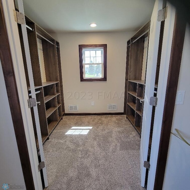 walk in closet featuring dark carpet