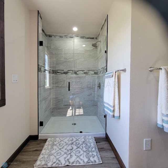 bathroom with hardwood / wood-style floors and an enclosed shower