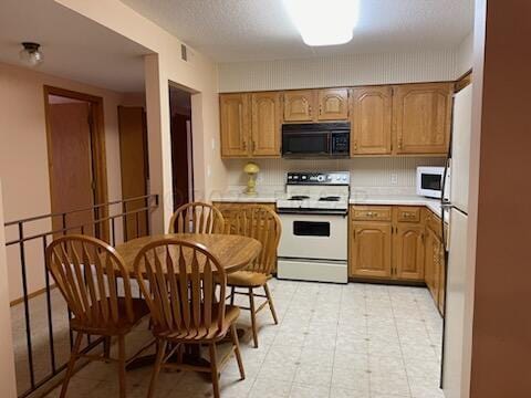 kitchen featuring white appliances and light tile floors