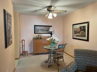 carpeted dining area with ceiling fan