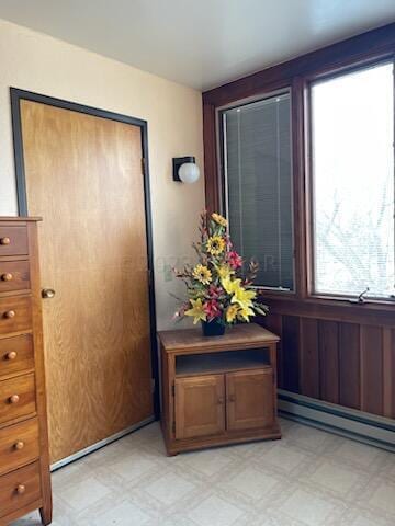 interior space featuring baseboard heating and light tile floors