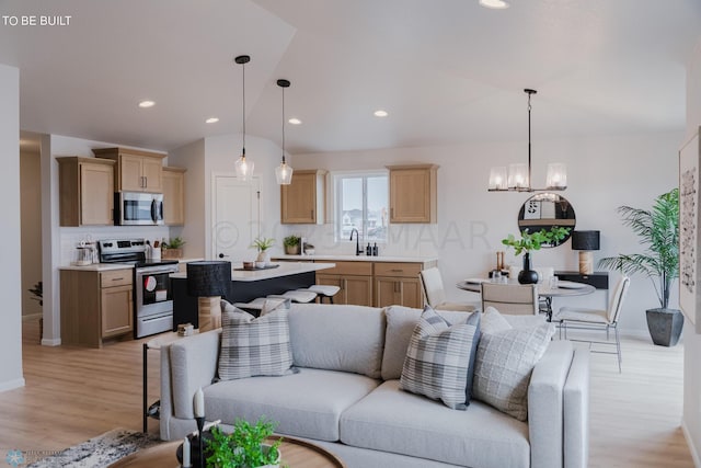 living room with a chandelier, light hardwood / wood-style flooring, and sink