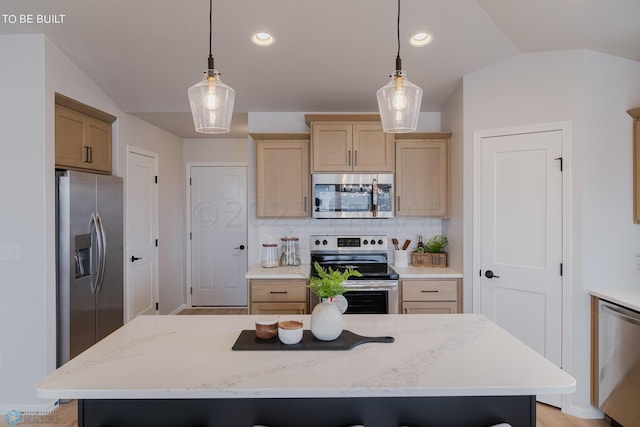 kitchen featuring appliances with stainless steel finishes, tasteful backsplash, a kitchen island, and decorative light fixtures