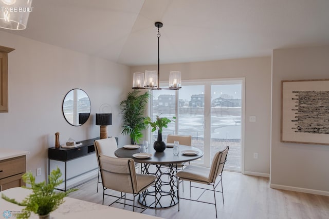 dining room with a wealth of natural light, light hardwood / wood-style floors, and a chandelier