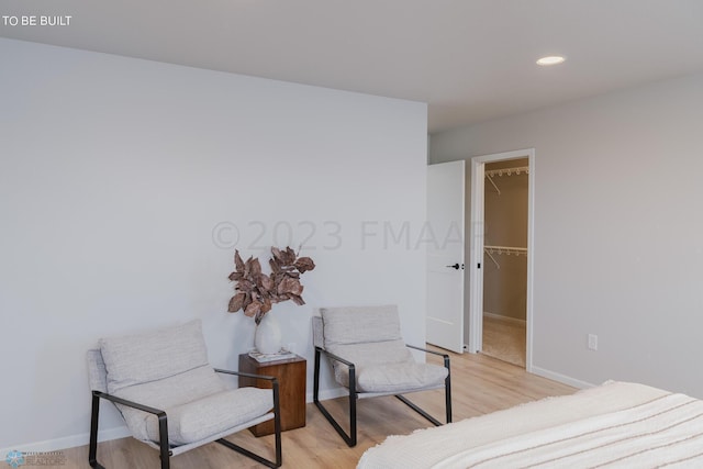 bedroom featuring a closet, light hardwood / wood-style floors, and a walk in closet