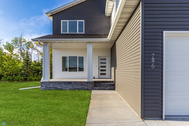 entrance to property with a garage and a yard