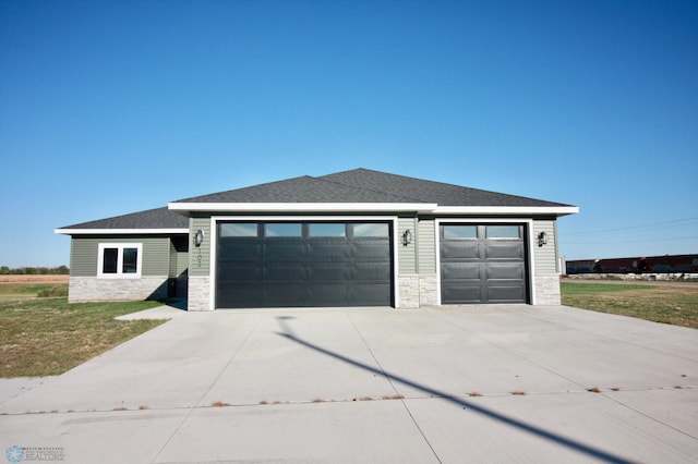 prairie-style home featuring a front yard and a garage