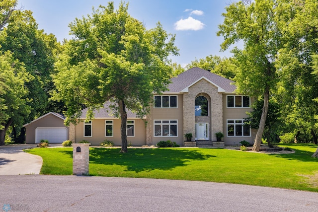 colonial inspired home with a garage and a front yard