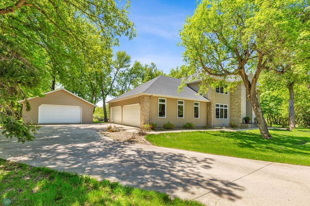 view of front of house with a garage, an outdoor structure, and a front yard