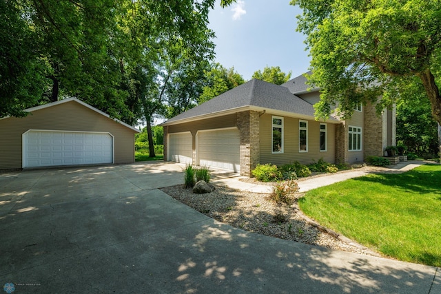 view of front of house featuring a garage, an outdoor structure, and a front yard