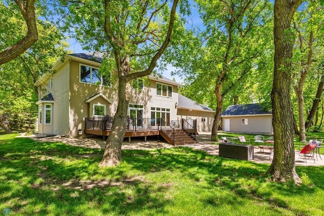 rear view of property featuring a patio area, a deck, and a lawn