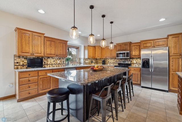 kitchen with light tile patterned flooring, a center island, backsplash, appliances with stainless steel finishes, and pendant lighting