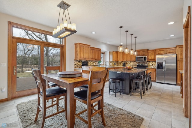 tiled dining area with an inviting chandelier and a textured ceiling