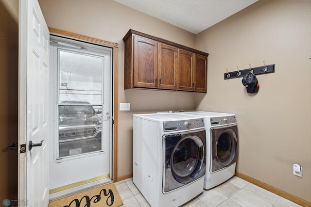 laundry room featuring cabinets, washer and dryer, and light tile patterned floors