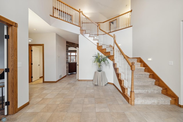 tiled entryway with a towering ceiling