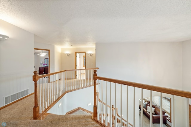 corridor featuring carpet flooring and a textured ceiling