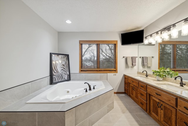 bathroom featuring dual vanity, tiled bath, a textured ceiling, and tile patterned flooring