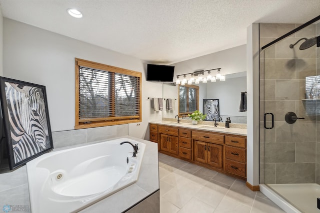 bathroom featuring separate shower and tub, a textured ceiling, tile patterned flooring, and double sink vanity