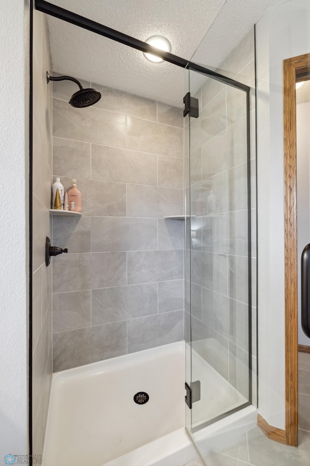 bathroom with walk in shower and a textured ceiling