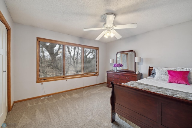 carpeted bedroom featuring a textured ceiling and ceiling fan