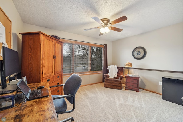 home office featuring light carpet, a textured ceiling, and ceiling fan