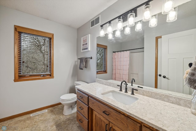 bathroom featuring tile patterned floors, toilet, vanity, and a textured ceiling