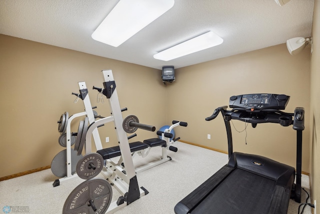 workout area with carpet floors and a textured ceiling