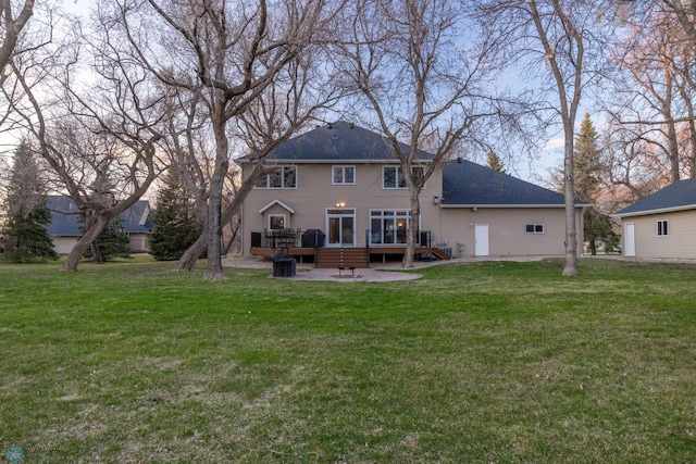 rear view of house with a patio area, a lawn, and a wooden deck