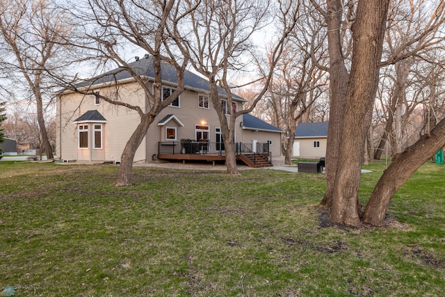 back of property with a yard and a wooden deck