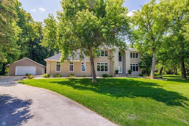 colonial house with a garage, an outdoor structure, and a front lawn