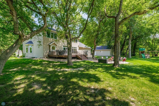 view of yard featuring a wooden deck and a playground