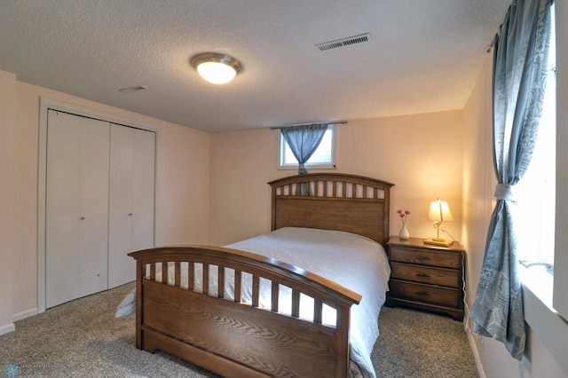 bedroom featuring a textured ceiling, a closet, and carpet floors