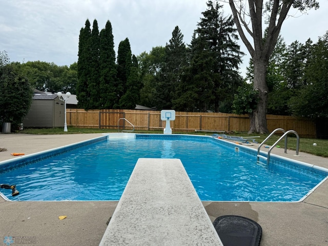 view of swimming pool with a patio and a diving board