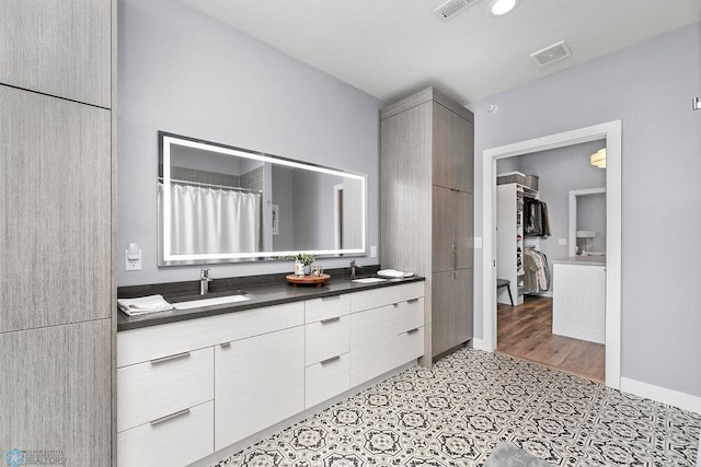 bathroom with tile floors and dual bowl vanity