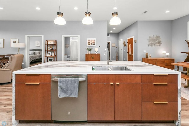 kitchen featuring sink, dishwasher, decorative light fixtures, and light wood-type flooring