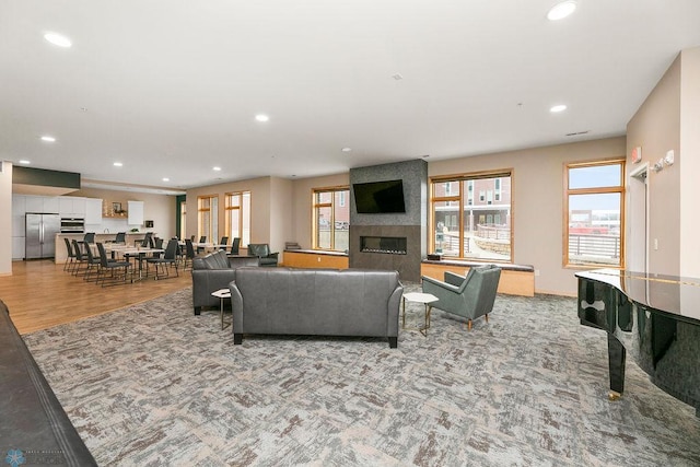 living room with a wealth of natural light, light hardwood / wood-style flooring, and a fireplace