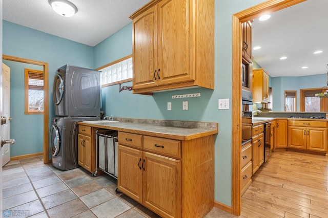 kitchen featuring plenty of natural light, stacked washing maching and dryer, and light hardwood / wood-style floors