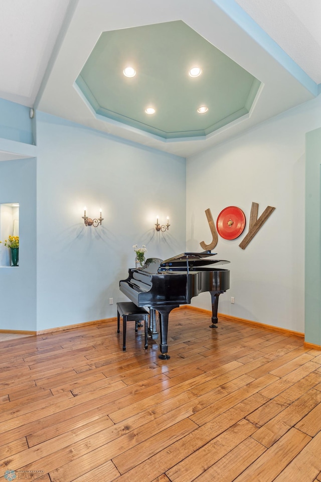 miscellaneous room featuring a raised ceiling and light hardwood / wood-style flooring