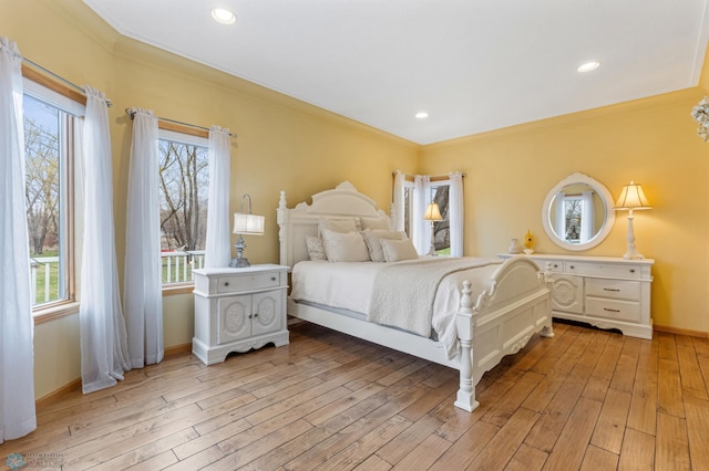 bedroom with ornamental molding and light hardwood / wood-style floors