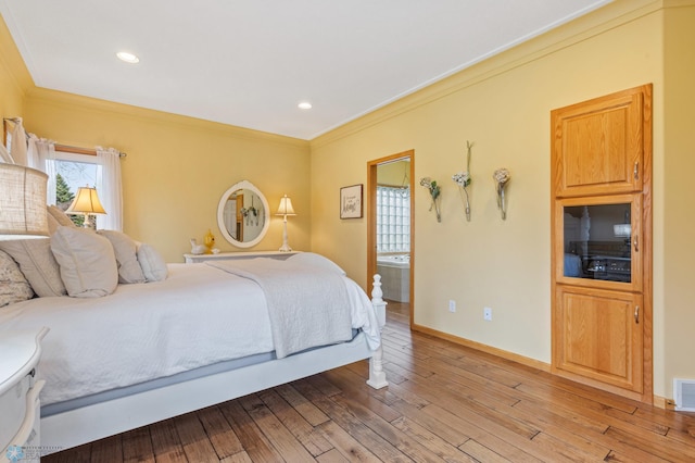 bedroom featuring light wood-type flooring, connected bathroom, and ornamental molding