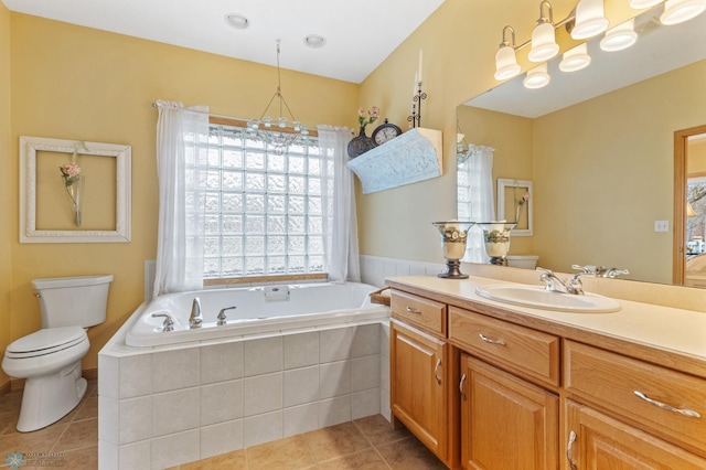 bathroom with toilet, tile patterned floors, a notable chandelier, a relaxing tiled tub, and vanity