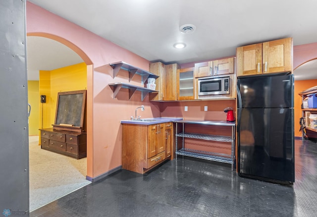 kitchen with stainless steel microwave, black fridge, and sink