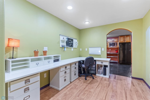 office space featuring light hardwood / wood-style floors and built in desk