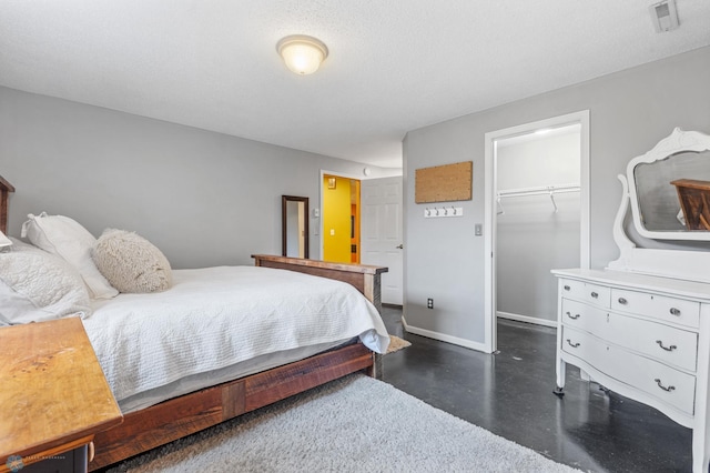 bedroom featuring a spacious closet, a closet, and a textured ceiling