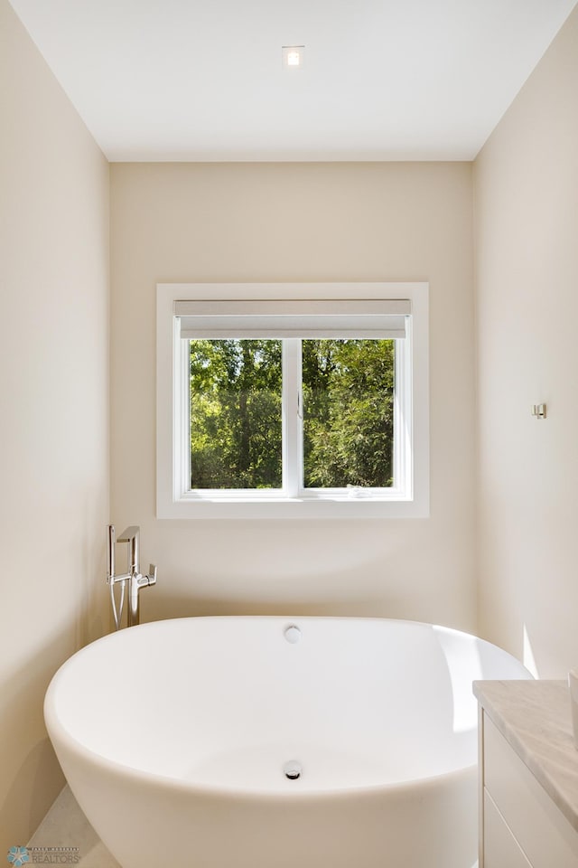 bathroom with vanity and a bath